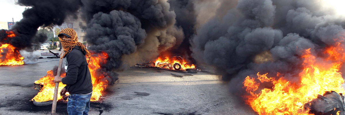 Un manifestante camina entre neumáticos ardiendo en la ciudad de Benghazi, febrero de 2014. Abdullah Doma/AFP/Getty Images