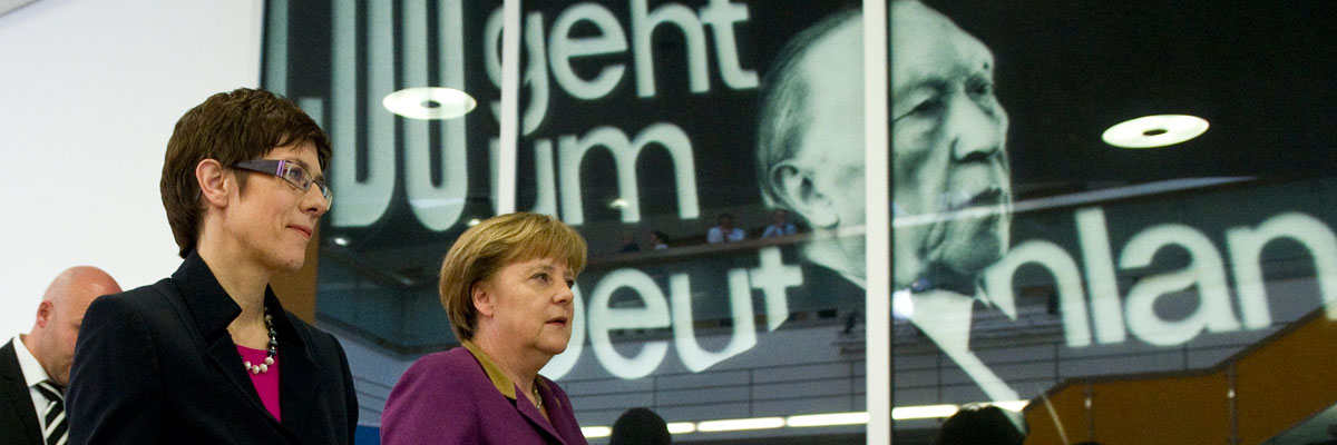La canciller alemana, Angela Merkel, pasa al lado deuna fotografía del ex canciller y padre fundador de la Unión Europea, or Konrad Adenauer. JOHN MACDOUGALL/AFP/Getty Images)