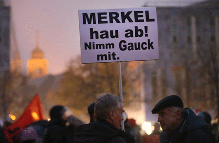 Simpatizantes del partido alemán AfD sostienen una pancarta que dice: "Merkel vete. Llévate a Gauck contigo" en Magdeburg. Sean Gallup/Getty Images