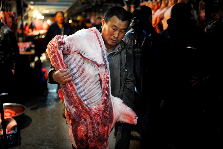 Un efecto de la globalización del sistema alimentario y la mejora del nivel de vida en todo el planeta ha sido el gran aumento del consumo de productos cárnicos, sobre todo, en China. En la imagen, un hombre carga un trozo de carne de cerdo en el mercado Hefei, al este de China. AFP/AFP/Getty Images