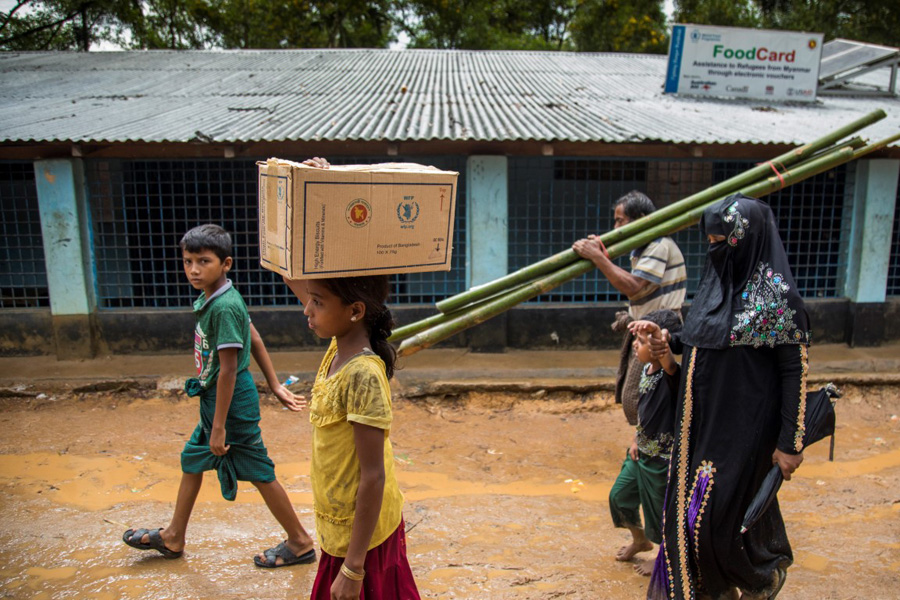 Una adolescente rohinyá transporta una caja de galletas en el campamento de refugiados de Kutupalong en Cox’s Bazar. Hasta la fecha, se han registrado a 540.000 personas para facilitarles alimentos en los próximos meses. (WFP/Saikat Mojumder)