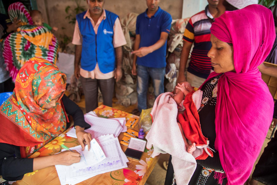 Para facilitar asistencia alimentaria es necesario comprobar que los datos personales están debidamente registrados. En la imagen, trabajadores humanitarios realizan comprobaciones para una mujer y su bebé en el campamento de Kutupalong en Cox’s Bazar. (WFP/Saikat Mojumder)