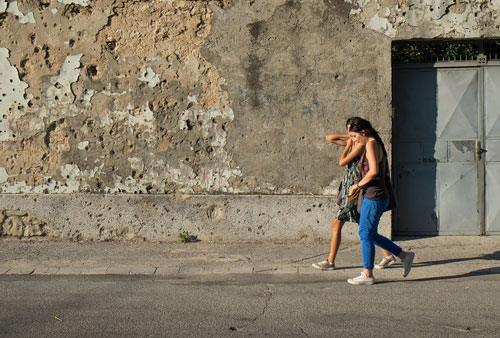 Dos chicas pasean al lado de un muro dañado por las balas durante la guerra en la ciudad de Mostar. Marco Secchi/Getty Images