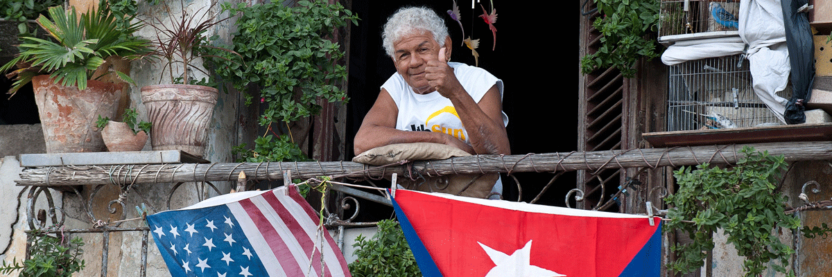 Un hombre en La Habana entre las banderas de Cuba y EE UU. (Yamil Lage/AFP/Getty Images)