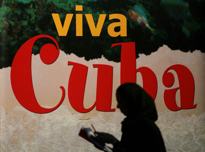Una mujer pasea a lado de un poster que promueve Cuba como destino en FITUR, la Feria Internacional del Turismo en Madrid, mayo de 2008. Pierre-Philippe Marcou/AFP/Getty Images