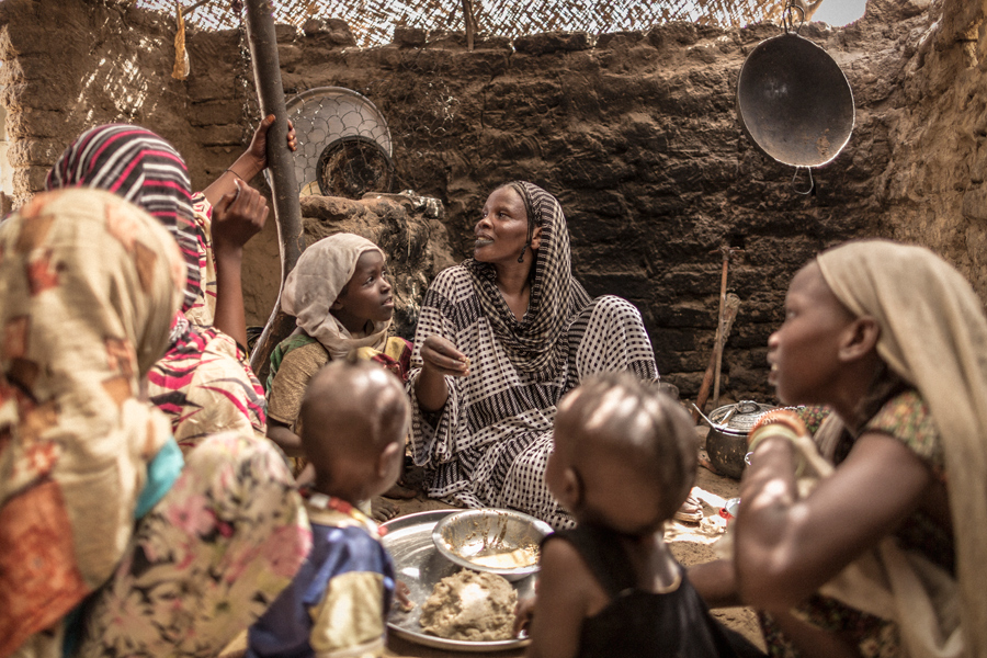 Achta (en el centro), rodeada por sus 10 hijos en Chad. Dejaron el norte del país escapando de la sequía. Ahora viven en una pequeña choza en la localidad de Arada, en el este del país. “Siempre comemos en familia”. © Programa Mundial de Alimentos/Chris Terry, con el apoyo de la UE.