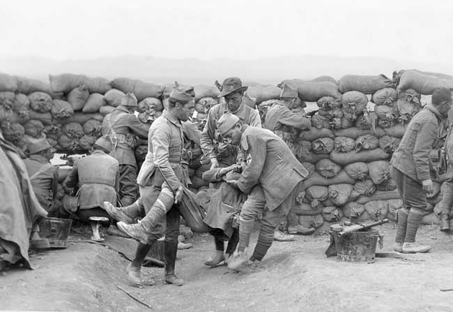 Guerra de Marruecos: José María Díaz Casariego. Marruecos, 3 de octubre de 1921. Unos soldados trasladan a un compañero herido mientras el resto de la unidad se defiende de los rifeños tras una muralla de sacos de arena.