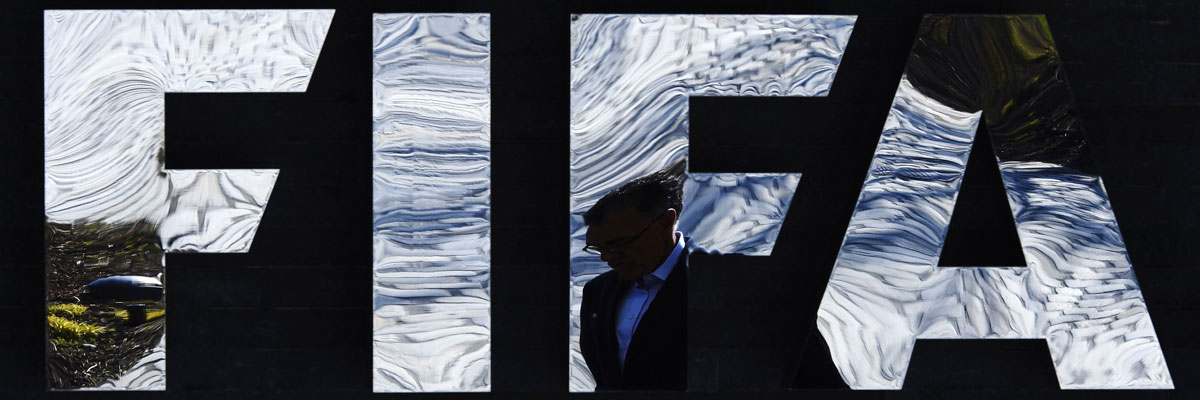 Un hombre pasa al lado del logo de la FIFA en Zurich, ciudad que alberga la sede de la organización. Michael Buholzer/AFP/Getty Images