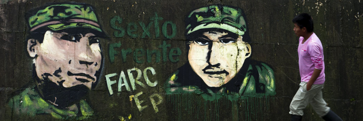 Un colombiano pasa en frente de un grafiti que hace alusión a las FARC en Cauca, Colombia, diciembre 2013. Luis Robayo/AFP/Getty Images