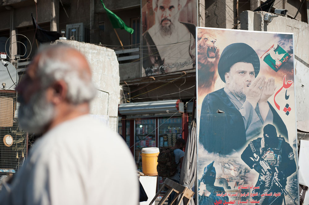 En una esquina de Bagdad cuelga una imagen del clérigo chií Moqtada al Sadr, una de las figuras políticas más controvertidas del periodo posterior a 2003. El clérigo entra y sale de la política de la Zona Verde. Encabezó los llamamientos a formar una milicia que luchara contra la ocupación estadounidense en 2004-2008. La lista electoral de su grupo, Sa’iroun, obtuvo 54 escaños en las elecciones de mayo de 2018, más que ningún otro partido. El movimiento sadrista ha demostrado su habilidad para explotar los cambios de ánimo de la calle iraquí. FOTO: CRISISGROUP/Julie David de Lossy