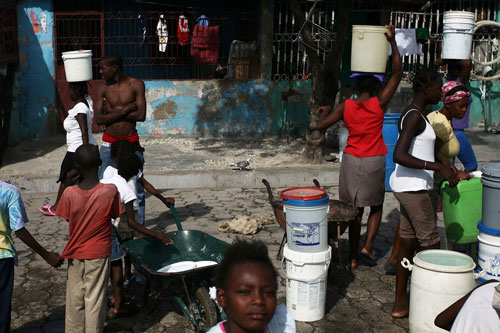 Haití: mujeres llevan baldes de agua en Cité Soleil, el mayor suburbio en las afueras de la capital haitiana, Puerto Príncipe, el 22 de noviembre de 2010. La bomba instalada en la ciudad escupe el agua clara, pero no tratada -los residentes debe agregar el cloro para evitar el cólera. El problema es que esos productos químicos son caros, así que la mayoría de los aproximadamente 300.000 habitantes de esta barriada extremadamente pobre en el norte de la capital corren el riesgo de contraer la enfermedad cada vez que beben agua.