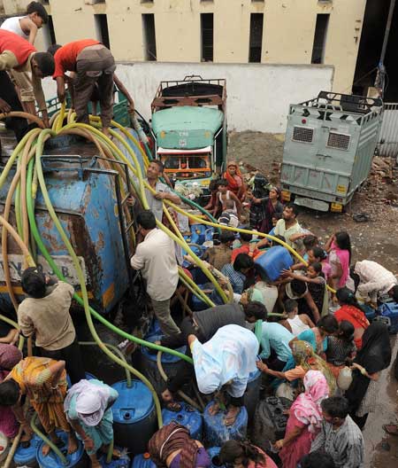 India: residentes de Nueva Delhi, se apresuran a llenar el agua de un camión cisterna en un barrio de la ciudad. La capital se enfrenta anualmente a la escasez de agua durante el verano, lo que dificulta el acceso a ésta por parte de los ciudadanos.