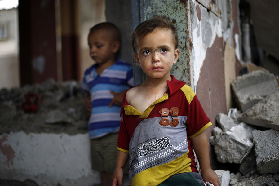 Israel y el Estado de Palestina: la escalada de tensión que desembocó en la Guerra de Gaza en el verano de 2014 tuvo efectos devastadores para los menores. Se estimó que entre el 6 de julio y el 26 de agosto murieron más de 10 niños al día, además, de los cerca de 3.000 niños heridos, al menos 1.000 quedarán discapacitados de por vida. Las hostilidades entre israelíes y palestinos llevan a que se perpetúe la impunidad en las violaciones de derechos humanos de su población. Dos niños entre los escombros de una casa destruida en la Franja de Gaza. Mohammed Abed/AFP/Getty Images