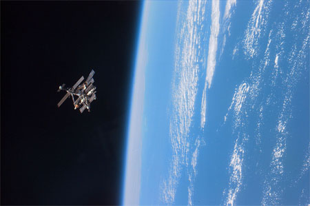 383927 03: FILE PHOTO: STS-79 astronauts enjoy this view of the Mir complex backdropped against the blackness of space over Earth's horizon. A thin blue line of airglow runs parallel with Earth's horizon, September 24, 1996. Mir is nearing the end of its existence as Russia plans to steer the craft out of orbit in late February 2001 in a controlled crash to dump the space station safely into the Pacific Ocean. (Photo by NASA/Newsmakers)