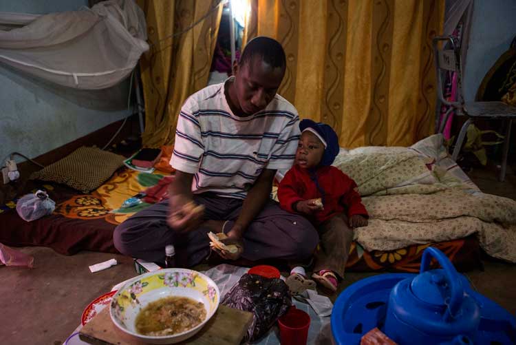 Malienses en Malí. El pastor Aziz Cisse intenta que su hijo de 18 meses, Etienne, que tiene malaria, desayune. Viven en un complejo saturado en Bamako donde se han refugiado más de 20 familias del Norte de Malí. Las esperanzas de volver a casa fueron en aumento después de que las tropas francesas comenzaran a expulsar a los separatistas de centros urbanos como Gao, Kidal y Tombuctú. Sin embargo, el Norte de Malí aún está lejos de ser seguro. Hasta entonces, muchos malienses desplazados tendrán que seguir sobreviviendo en Bamako. ACNUR/G.Gordon
