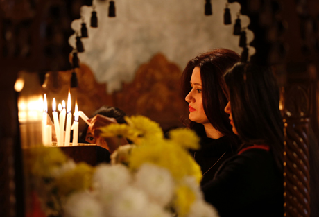 Una mujer palestina y cristina enciende unas velas en una iglesia. Mohammed ABed/AFP/Getty Images 