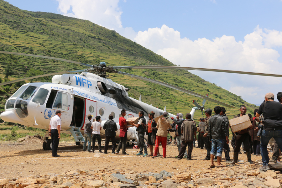 Nepal, mayo de 2015. Tras el terremoto de 2015, los helicópteros de UNHAS paliaron las dificultades de acceso a las áreas más afectadas en las montañas. En la imagen, una cadena humana descarga alimentos y tiendas de campaña en Kerauja, en el distrito de Gorkha. Crédito: WFP/Angeli Mendoza
