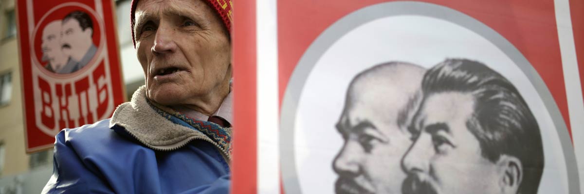 Un hombre sostiene un retrato de Vladímir Lenin y Iosif Stalin durante la conmemoración de la Revolución Bolchevique en Crimea. Max Vetrov/AFP/Getty Images