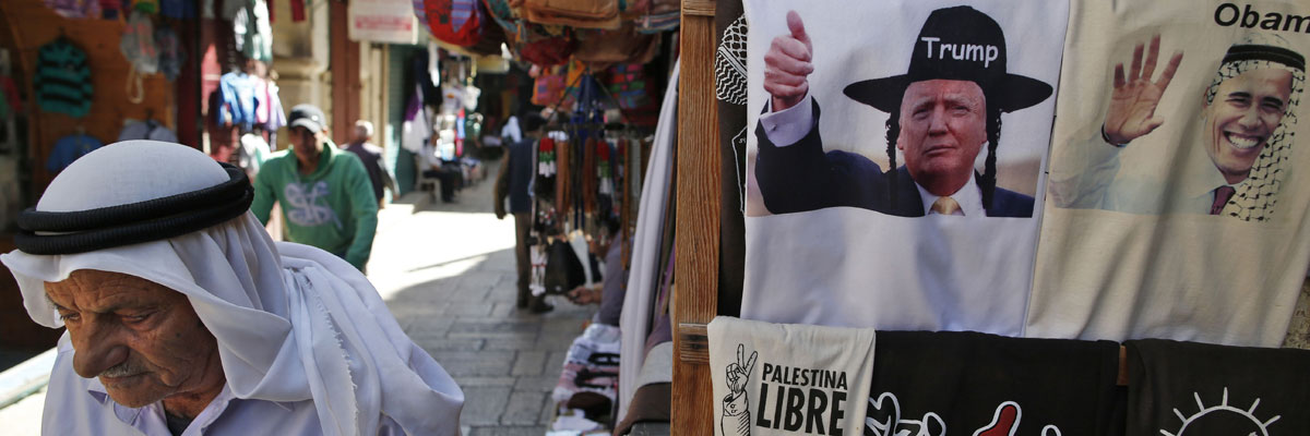 Un palestino camina al lado de una tienda de souvenir donde hay camisetas con las caras de Donald Trump y Barack Obama, Jerusalén. Ahmad Gharabli/AFP/Getty Images