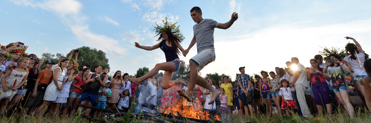 Una pareja de ucranianos salta sobre una hoguera durante la celebración de una fiesta tradicional eslava (Sergei Supinsky/AFP/Getty Images).