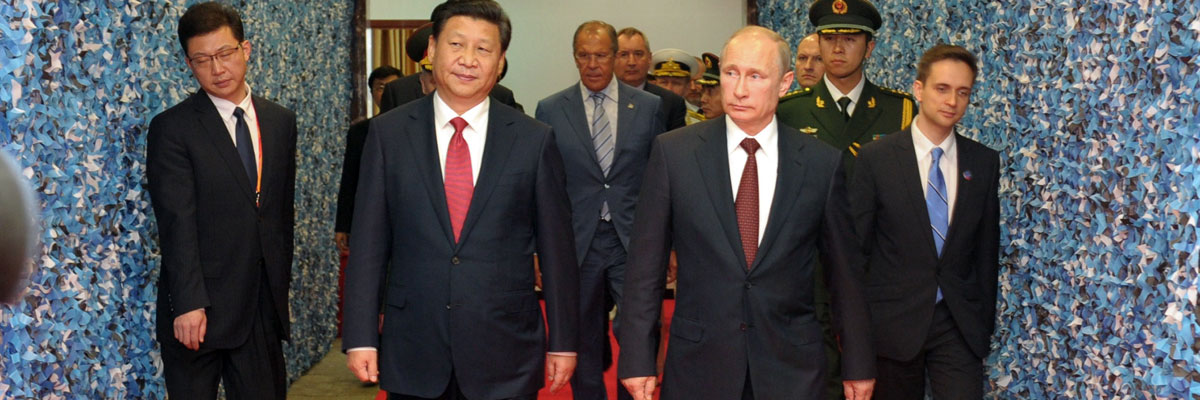 El presidente chino, Xi Jinping (izquierda) y su homólogo ruso, Vladímir Putin (derecha), en la ceremonia de apertura de unos ejercicios navales conjuntos, mayo 2014. Alexey Druzhinin/AFP/Getty Images