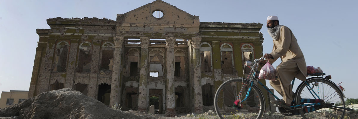 Un hombre afgano pasea en bicicleta cerca de un edificio en ruinas a causa de la guerra. Shah Marai/AFP/Getty Images