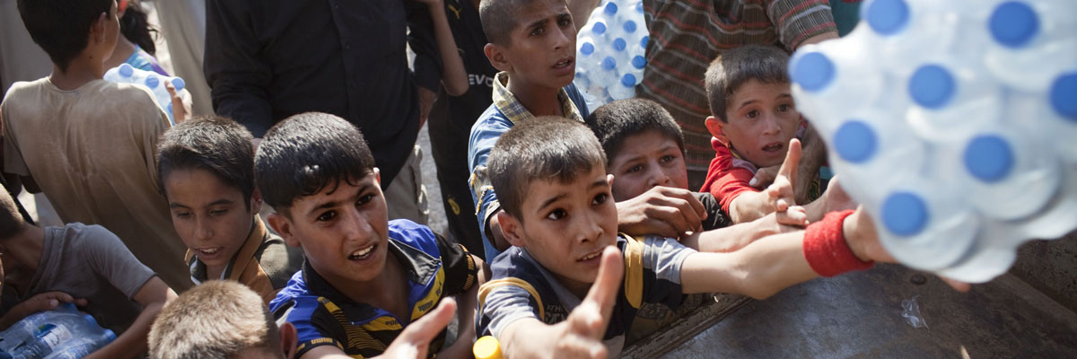 Niños iraquíes reciben agua de un convoy con ayuda humanitaria después de que el Ejército de Irak se hiciera con el control de un pueblo sitiado por los yihadistas. JM López /AFP/Getty Images