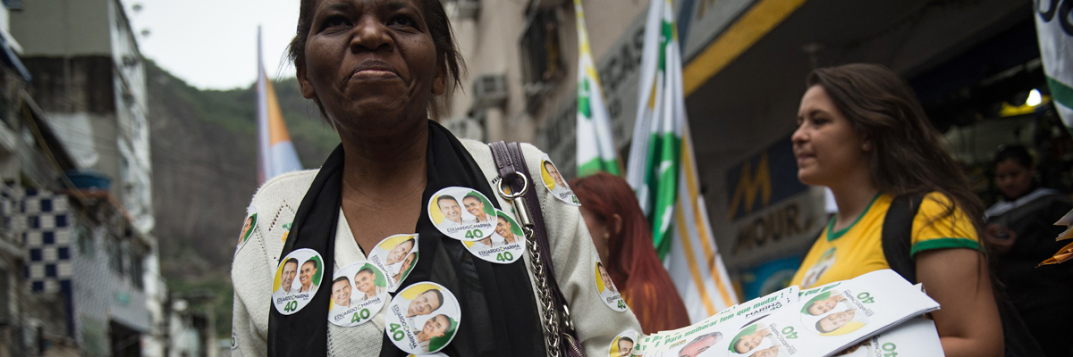Partidarias de la candidata presidencial por el Partido Socialista Brasileño (PSB), Marina Silva, distribuyen pegatinas e información durante la campaña electoral en la favela Rocinha en Río de Janeiro. (Yasuyoshi Chiba/AFP/Getty Images)