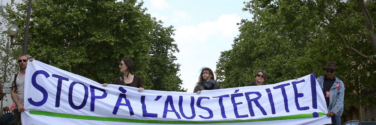 Un grupo de personas sostiene una pancarta que pide el fin de las medidas de austeridad durante una manifestación en París, mayo de 2014. Kenzo Tribouillard/AFP/Getty Images