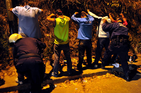 La policía venezolana registra en busca de drogas y armas a un grupo de hombres. Geraldo Caso/AFP/Getty Images
