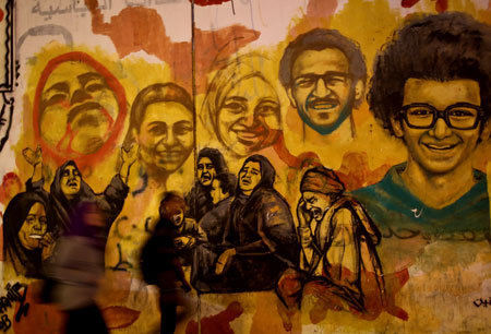 Egipcios pasean al lado de un graffiti que conmemora el aniversario de las protestas de 2011. Mohamed el Shahed/AFP/Getty Images)