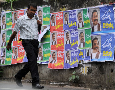 Un hombre pasea al lado de carteles con el retrato del presidente Mahinda Rajapakse en la ciudad de Kandy, noviembre 2014. S. Kodikara/AFP/Getty Images