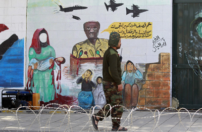 Un soldado hutí frente a un grafiti pro huti en la capital Saná, Yemen. Mohammed Huwais/AFP/Getty Images