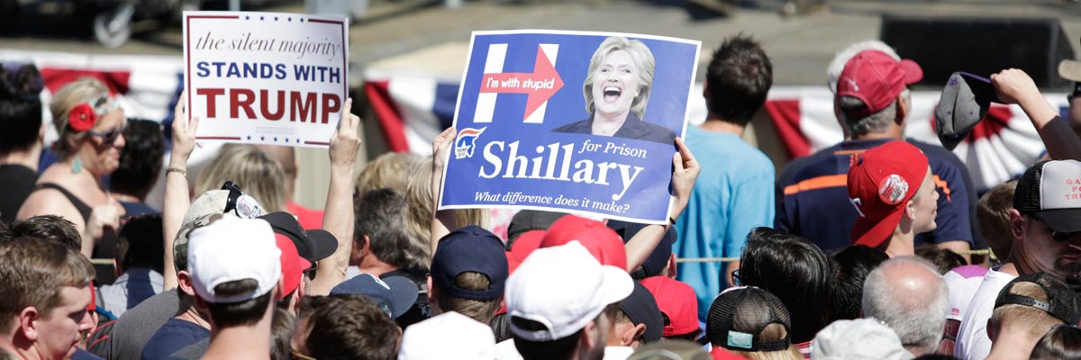 Defensores de Donald Trump sostienen pancartas que se mofan de Hillary Clinton. Ason Redmond/AFP/Getty Images