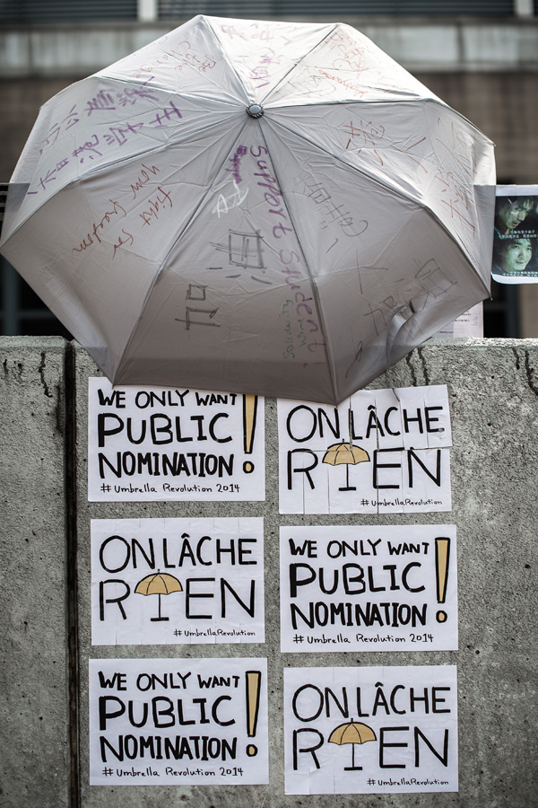 Un paraguas como icono. Todas las protestas tienen un símbolo y en las protestas de Hong Kong lo es el paraguas amarillo o simplemente un paraguas cubierto con mensajes. Se ha creado incluso la dirección de Twitter @umbrellaRev. En la imagen un paraguas y mensajes escritos en francés e inglés (Philippe Lopez/AFP/Getty Images).