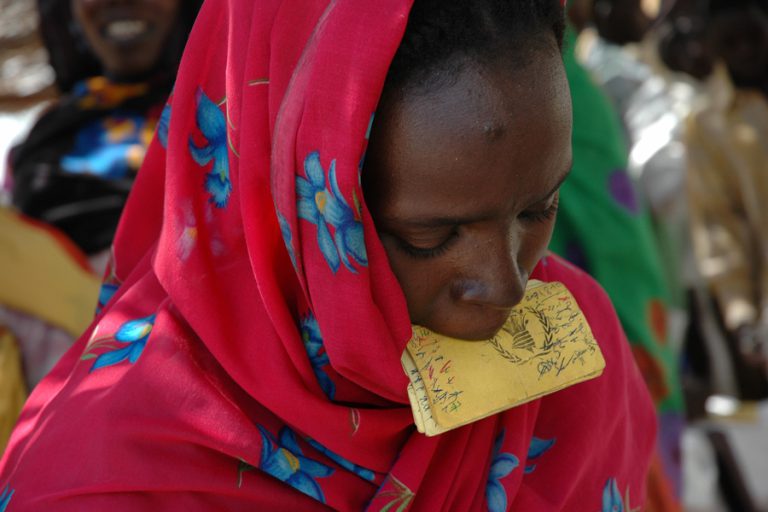 Participante del programa de distribución general de alimentos, con su tarjeta identificativa. Kabkabiya, Darfur, Sudán, 2006. Fuente: Programa Mundial de Alimentos/Diego Fernández