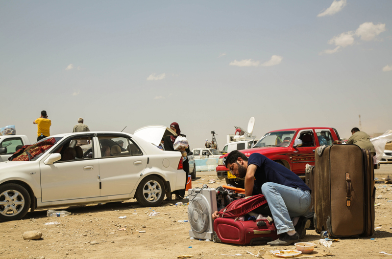 El hombre de la fotografía huyó de Mosul en coche. Revisa sus pertenencias antes de iniciar el camino a pie hasta el punto fronterizo de Khazair. Sus planes son viajar hasta Erbil. Muchos otros han llegado tenido que dejar atrás todas sus pertenencias. Fuente: ©ACNUR/UNHCR / R. Nuri