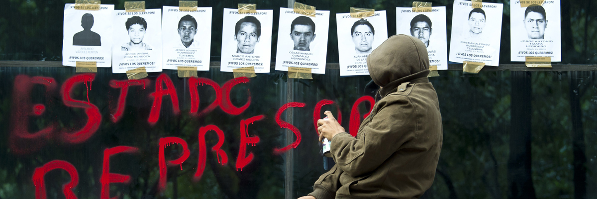 Un estudiantes pinta en las ventanas de la Fiscalía General protestando por la desaparición de 43 estudiantes en Iguala (Omar Torres/AFP/Getty Images).