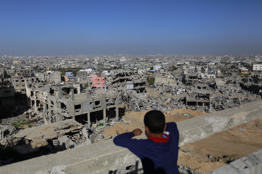 Gaza: El 8 de julio se inicia la operación Margen Protector por parte del Ejército israelí sobre la Franja de Gaza. La tregua definitiva se alcanza el 26 de agosto. El balance total de muertos palestinos se sitúa en torno a 2.100 (entre ellos 500 niños); además 11.000 palestinos resultan heridos, se destruyen 20.000 de sus viviendas y 110.000 palestinos son desplazadas. Por parte israelí se cuentan 70 bajas: 64 soldados y 6 civiles, entre ellos un niño. En la imagen, un niño palestino observa la ciudad de Gaza el 10 de diciembre. Mohammed Abed/AFP/Getty Images.