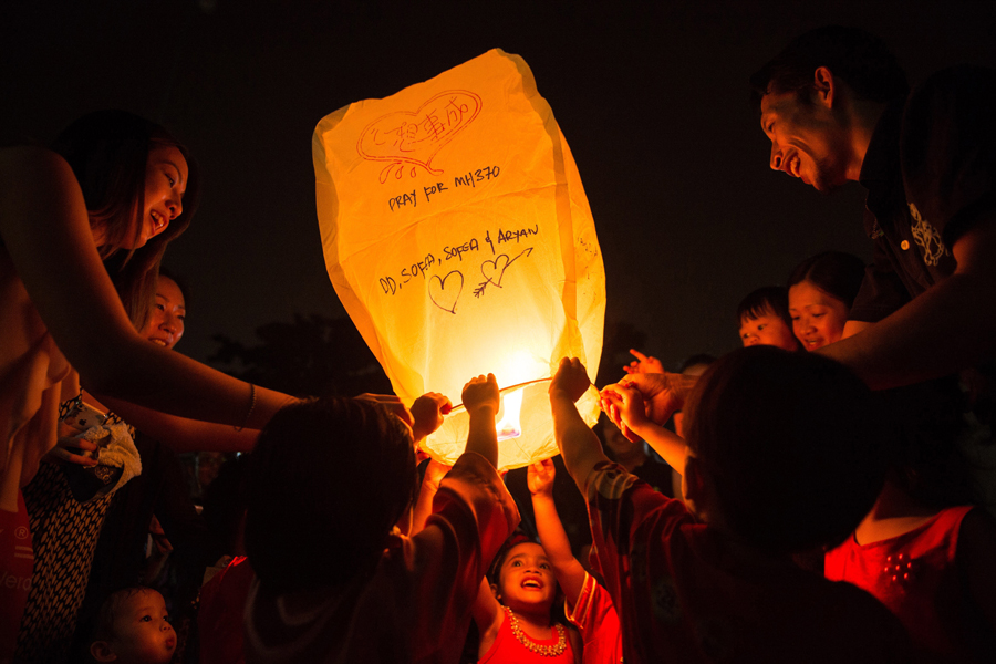 Malaysia Airlines: El 8 de marzo desaparece un avión de Malaysia Airlines que transportaba 239 pasajeros. Días después se confirma que el avión sufrió un accidente en el Océano Índico. El 28 de diciembre un avión malasio de AirAsia se hunde en el mar con 162 pasajeros. En la imagen, varios padres y sus hijos lanzan un farol con un mensaje escrito para los desaparecidos del vuelo MH370 en un evento escolar en Amapang, cerca de Kuala Lumpur, el 13 de septiembre. Mohd Rasfan/AFP/Getty Images.