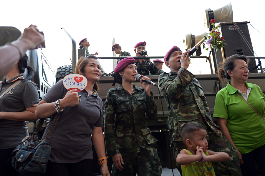 Golpe de Estado en Tailandia: El 22 de mayo las Fuerzas Armadas de Tailandia llevan a cabo un golpe de Estado contra el Gobierno interino de Niwatthamrong, tras el cual una junta militar toma los mandos del país. En la imagen, Militares tailandeses cantando. Christophe Archambault/AFP/Getty Images.