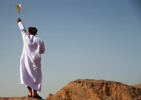 Un omaní con una bandera del país (Bryn Lennon/Getty Images)
