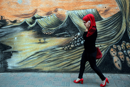 Una mujer palestina camina frente a un grafiti que ilustra la Nakba, en referencia al nacimiento del Estado de Israel, en Ramala, Cisjordania. (Abbas Momani/AFP/Getty Images)