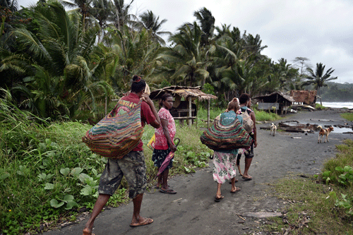 Mujeres cargando leña en Kerema, Nueva Guinea (Aris Messinis/AFP/Getty Images)