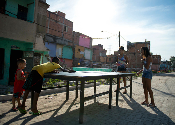 TENIS DE MESA: Un grupo de niños juega al tenis de mesa o ping-pong en Manguinhos, un barrio de favelas de Río de Janeiro. Aunque en proceso de envejecimiento, en la actualidad un 40 % de la población de Brasil se sitúa en la franja de edad que corresponde a la juventud,es decir, hasta los 24 años. BUDA MENDES/LatinContent/Getty Images