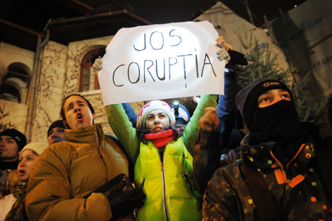 Una joven rumana sostiene una pancarta que dice “Abajo con la corrupción” durante una protesta en Bucarest. Daniel Mihailescu/AFP/Getty Images
