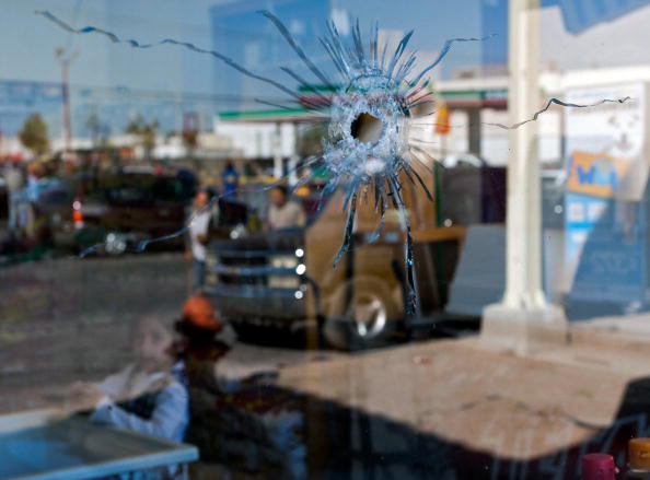 Una niña en Ciudad Juárez, México, mira hacia el agujero de bala en una ventana tras un tiroteo en la ciudad. (Jesús Alcazar/AFP/Getty Images) 