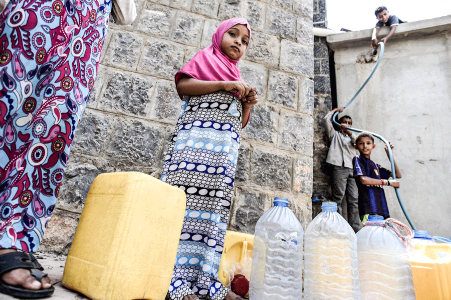 Jóvenes tratan de llenar botellas con agua acumulada en el tejado de un colegio de Hajja, ciudad del norte de Yemen. Antes del embargo, los vecinos ya sufrían severos cortes de electricidad y agua, ahora con los bombardeos la situación es crítica. Julio de 2015/Natalia Sancha