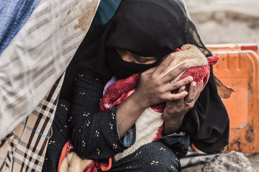 La desplazada Ahlan Nasser ha perdido a tres hijos en los tres primeros meses de los bombardeos. Hoy se aferra a su pequeña recién nacida Rahma (Clemencia en árabe) de 11 días de vida. 65 familias de la región Al Bouq, fronteriza con Arabia Saudí y duramente castigada por los bombardeos, buscan refugio en un asentamiento informal en la localidad de Amran, a unos 40 kilómetros al norte de Saná. Las mujeres mendigan durante el día en una carretera colindante para poder alimentar a sus hijos. Muchas han dado a luz en las maltrechas tiendas por falta de recursos para pagar a una comadrona privada. Julio de 2015/Natalia Sancha