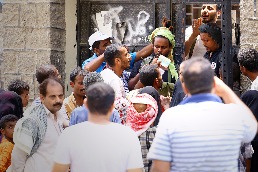El Programa Mundial de Alimentos (PMA/WFP) ha repartido alimentos entre casi 5 millones de personas en 17 provincias de Yemen desde que comenzó el conflicto en abril, a pesar de los tremendos obstáculos. En ellas están incluidas todas las zonas con niveles de “emergencia” de inseguridad alimentaria salvo Al Baida, a la que es difícil llegar desde que empezaron los enfrentamientos. En la foto, habitantes del distrito de Al Tuwwahi, en Adén, se reúnen en un punto de distribución para recoger la ayuda, consistente en legumbres, aceite vegetal y harina de trigo. © PMA-WFP/Ammar Bamatraf
